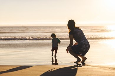 Donna che ammira il tramonto sulla spiaggia.