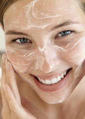 volto di una donna che si spalma la crema sul viso