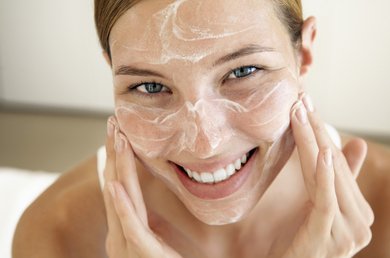 volto di una donna che si spalma la crema sul viso
