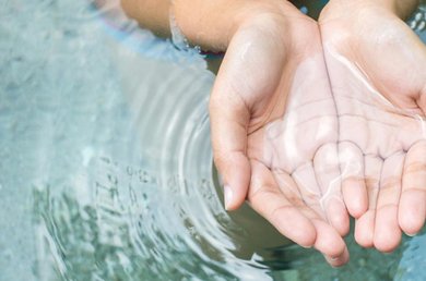 una mano che tocca delicatamente l'acqua