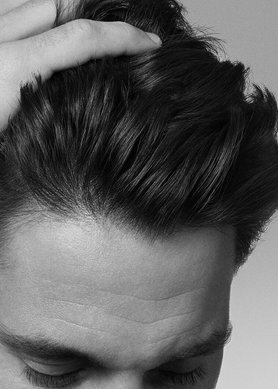 volto di un uomo che si tocca i capelli