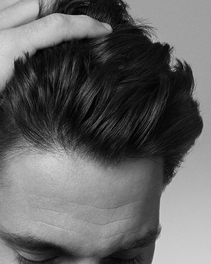 volto di un uomo che si tocca i capelli