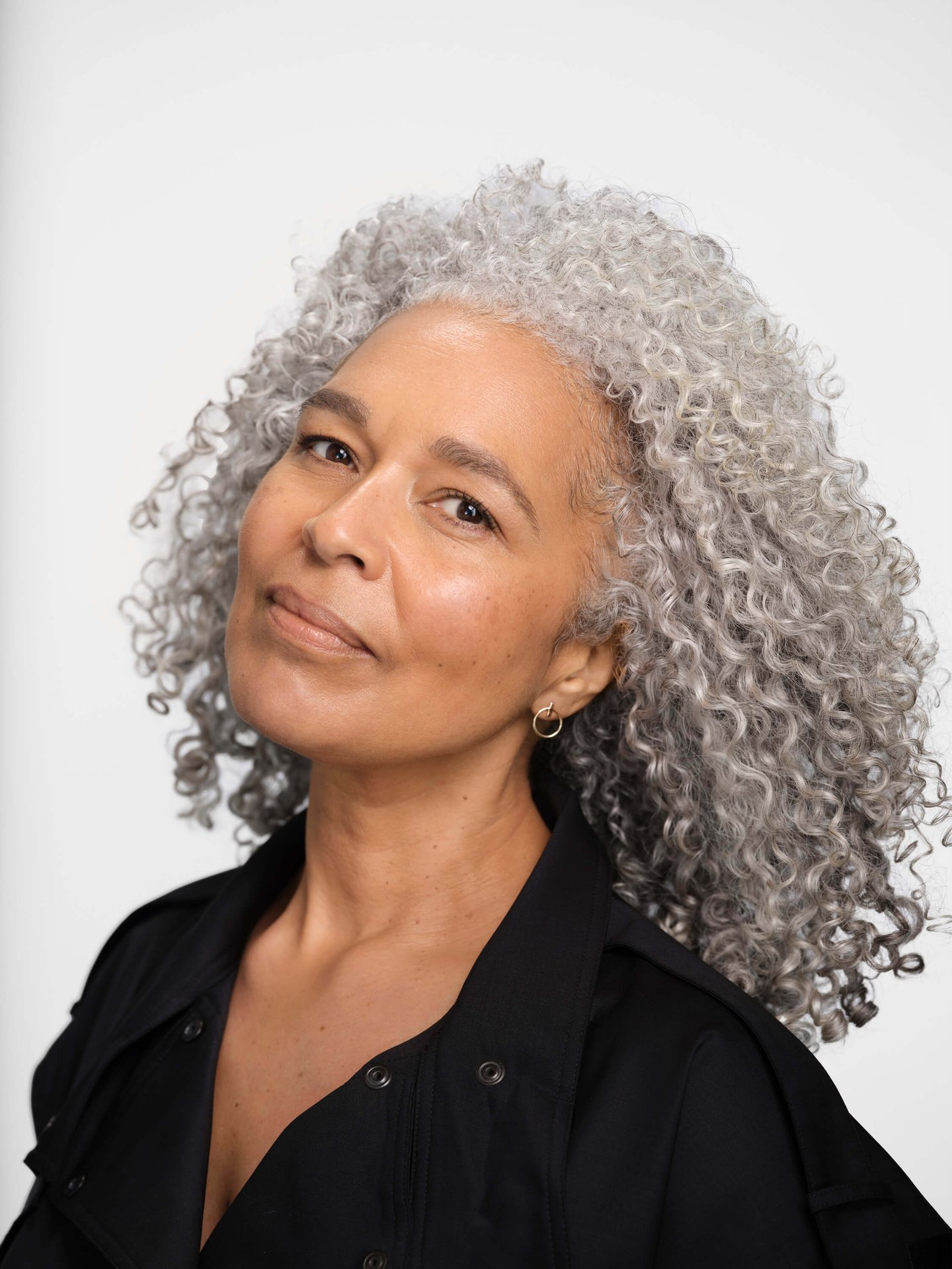 donna con capelli ricci e grigi, leggermente sorridente